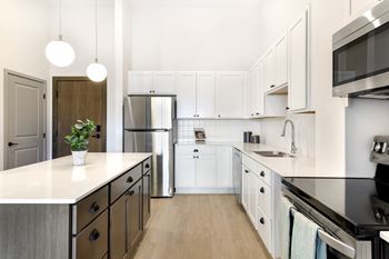 A modern kitchen with white cabinets and stainless steel appliances.